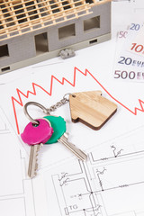 Keys with home shape, euro and downward graphs on construction diagrams of house. Real estate...