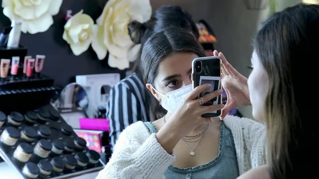 Young hispan cute artist woman beauty vlogger or blogger doing a cosmetic makeup tutorial vlog.