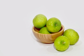 Closeup of Fresh Green jujube in a wooden bowl isolated on white background, Selective Focus.