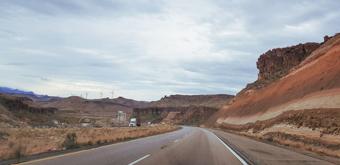 road through the mountains with wind farms in backdrop