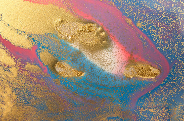 Marbled blue and pink abstract background with golden glitter.
