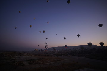 Hot air balloon flying over rock landscape at Cappadocia Turkey