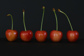 Ripe red cherries on black background.
