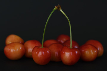 Ripe red cherries on black background.
