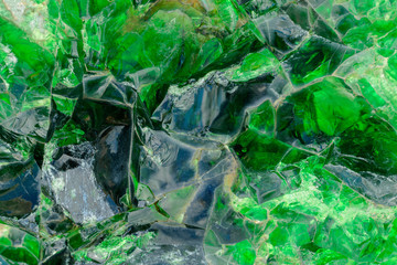 Abstract surface from crystal glass. Color - green, blue. Scratches, glare, sharp edges.
