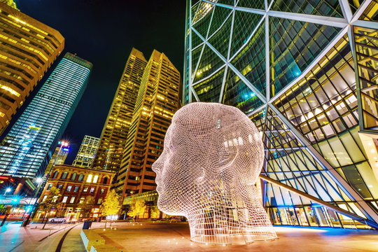 Alberta, Canada, SEP 29, 2017 - Night view of the popular "Wonderland" sculpture by famous artist Jaume Plensa sits in-front of The Bow tower in Calgary, Alberta,Canada