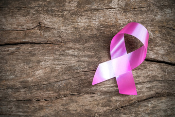 healthcare and medicine concept. pink breast cancer awareness ribbon on wood table. Top down of the...