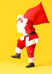 African-American Santa Claus with bag on color background