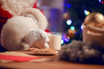 Santa Claus eating cookies and drinking milk, closeup