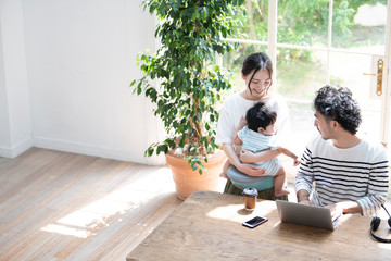 自宅でリモートワークしながら子どもと会話するヒゲの中年男性とその家族 広角 コピースぺ-スあり