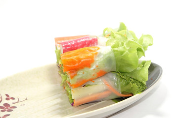 Roll salad is a healthy food for people who take care of the body.It has mainly organic greens on a white background.