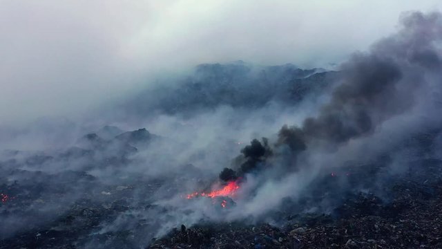 Aerial view of a burnt nature full of smoke and fire, caused by the Californian wildfires, in Los Angeles, California, USA - dolly, drone shot