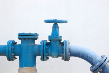 Large water supply valve with a white background of the cement wall