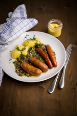Oldenburger Gr&uuml;nkohl mit Pinkel, Kohlwurst, Senf und Kartoffeln auf Holz Tisch