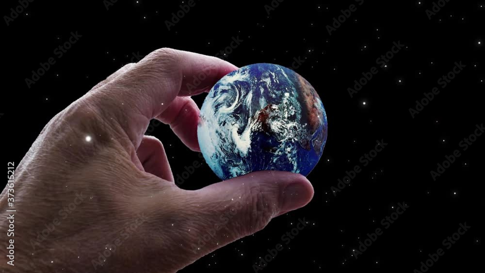 Wall mural video of universe or aerial flyby. camera moves towards hand holding planet earth while stars flyby.