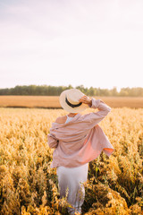 Naklejka na ściany i meble a girl in a straw hat with her back to the field