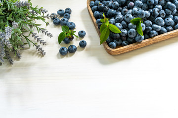 Blueberries on a wooden tray on a white background with copy space