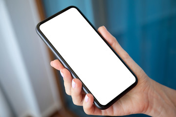 female hand holding phone with isolated screen on blue background
