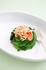 seasoned spinach topped with noodle