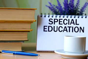 SPECIAL EDUCATION - word in a notebook on a background of old books with pen and white cup