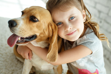 Little girl with a dog at home. High quality photo.