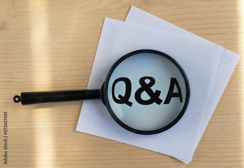 Poster questions and answers concept - q and a - magnifying glass on wooden background