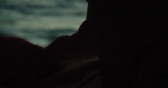 Close up of woman's dress billowing in the wind as she stands looking out towards the ocean