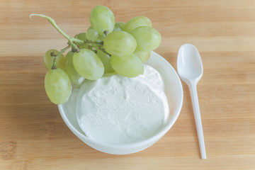 white ice cream with a bunch of grapes and a spoon  