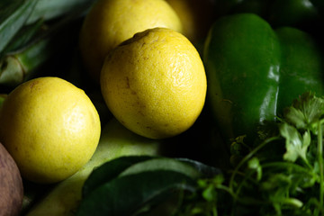 close up of fresh Lemons placed amoungst other vegitables.