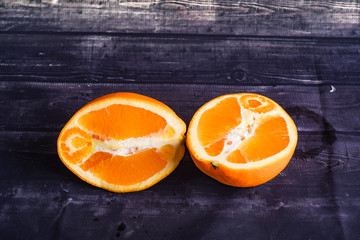 ripe orange on a dark wood background. Orange cut close-up