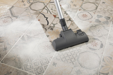Vacuum cleaner on porcelain stoneware floor with copyspace for text message