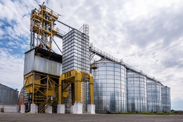 Modern Granary elevator. Silver silos on agro-processing and manufacturing plant for processing drying cleaning and storage of agricultural products, flour, cereals and grain. © hiv360