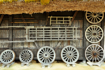 Rustic looking facade of old traditional Japanese house made of wood with bamboo roof and wooden wheels in the front