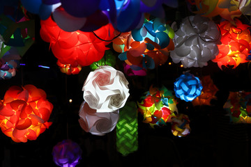 Colorful lanterns or lamps, with various patterns, forms and colors, illuminated in a street stall at a famuse night market, Tha phae gate walking street, Chiang mai, Thailand. Thai lantern concept.