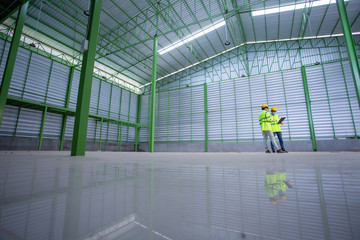 Asian Industrial Engineer in Hard Hat Wearing Safety Jacket plan work with warehouse workers Processes in the factory.