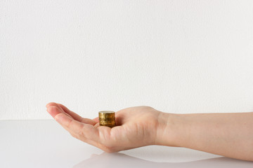 Money, stack of coins on hand. Donation, charity, finance or investment concept. White background, copy space.