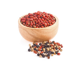 dried pink peppers in wood bowl isolated on white background