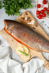 Smoked fish trout. Whole Smoked trout on the serving Board. Smoked trout lay on the light gray kitchen table. Smoked fish close-up	