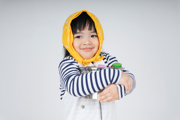 asian thai kid play role as a waitress wearing yellow bandage hugging cooking pot isolate over white background.