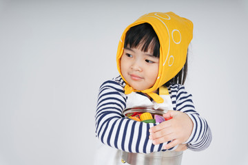 asian thai kid play role as a waitress wearing yellow bandage hugging cooking pot isolate over white background.