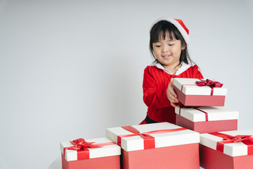 Pretty asian thai kid woman in santa claus uniform with christmas gift box for celebrating.