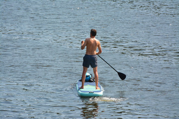 a man stands up paddle board in a river