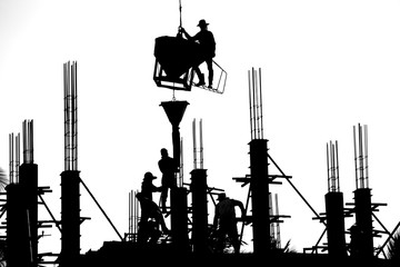 Construction workers are casting columns to build buildings using cranes. It is a black and white style picture.