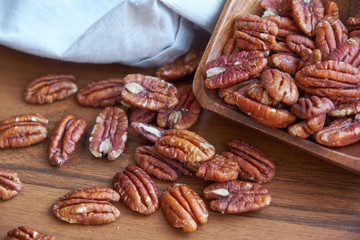 pecan nuts in wood bowl on old brown table, selective focus. top view. Healthy food and snack.