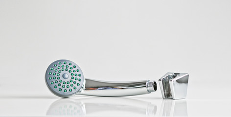 Obraz premium New shiny shower head and wall mount for it. On a light background. Materials for plumbing works.