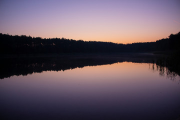 Fototapeta na wymiar Fioletowo- różowy zachód słońca nad jeziorem