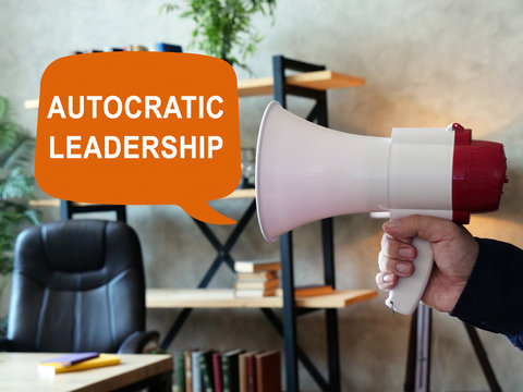 Autocratic leadership concept. Loudspeaker in hand and inscription.