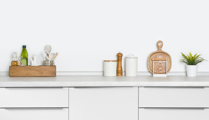 Contemporary utensils and spices standing on kitchen countertop with space