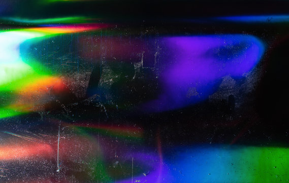Abstract background of holographic strings of all rainbow colors with dust and scratches.