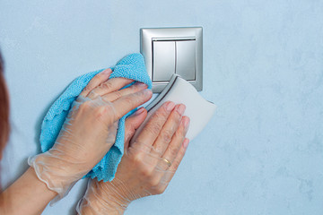 Woman hands in vinyl gloves with melamine sponge and wipe for housekeeping. Disinfecting surfaces in the house.